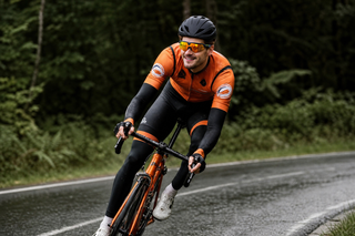 Cyclist cornering on a wet forest road in the rain wearing camera glasses