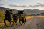 Loaded touring bicycle on a quiet road with distant hills